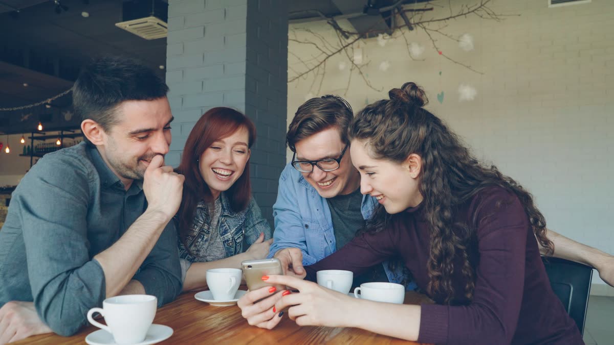 Two people discussing a friendship app at a cafe